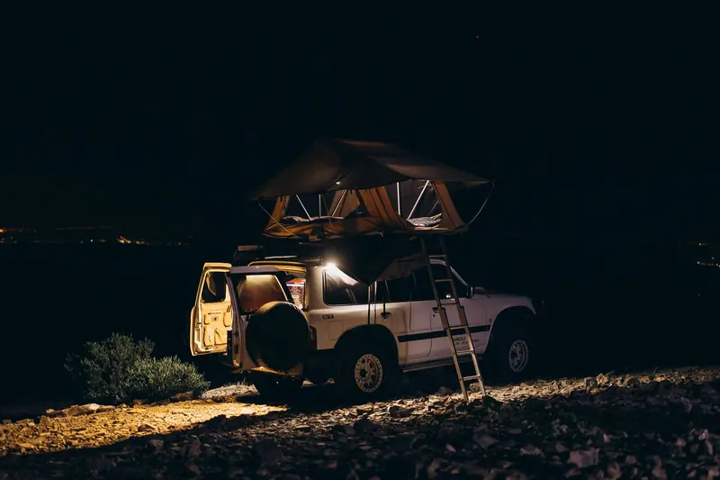 Explore 4x4 off-road camping under a vibrant starry night sky in the scenic landscapes of Oman