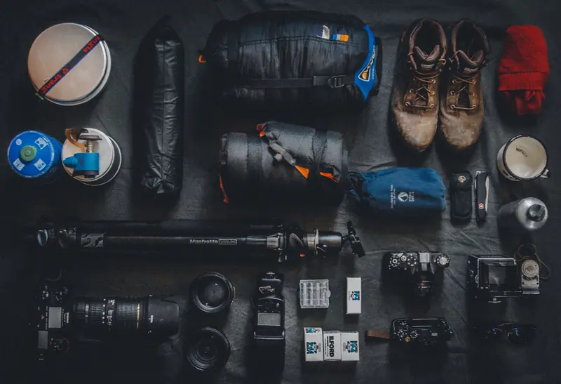 Flat lay of outdoor camping and photography equipment neatly organized